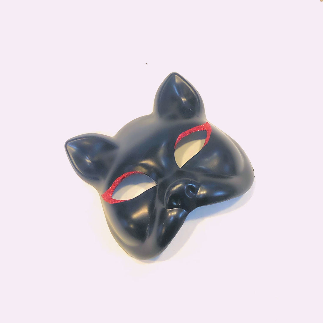 Black cat masquerade mask with red glitter accents around the eyes.