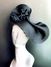 Black fascinator hat with butterfly accents and netted veil for gothic Halloween or masquerade fashion.