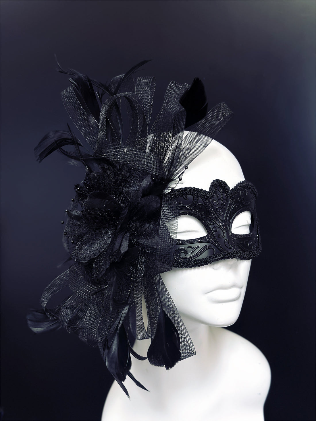 Elegant black feather masquerade mask with lace-inspired detailing and satin ribbons, perfect for masquerade balls and Halloween parties.
