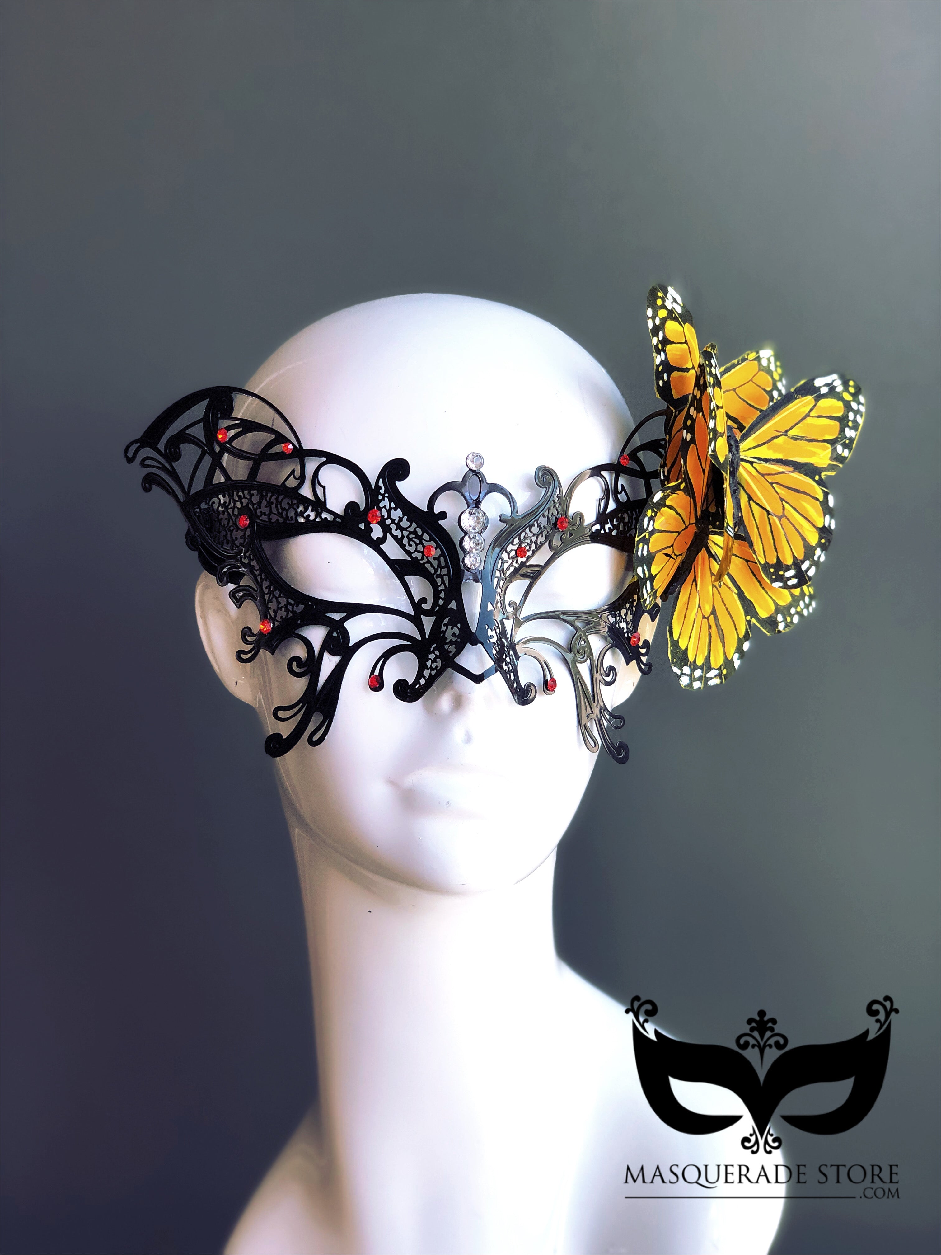 Black filigree masquerade mask with rhinestones and yellow butterfly accent, perfect for costumes and balls.