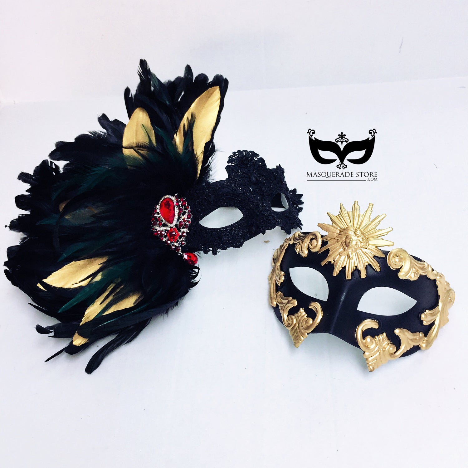 Black and gold couples masquerade mask set with men’s baroque sun mask and women’s feather lace mask with red jewel.