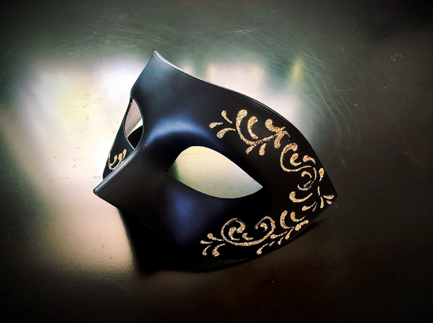 Elegant black half-face masquerade mask with floral gold accents