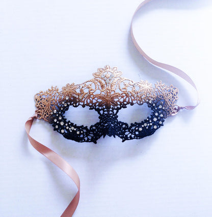 Elegant black and gold masquerade mask with filigree lace and ribbon ties