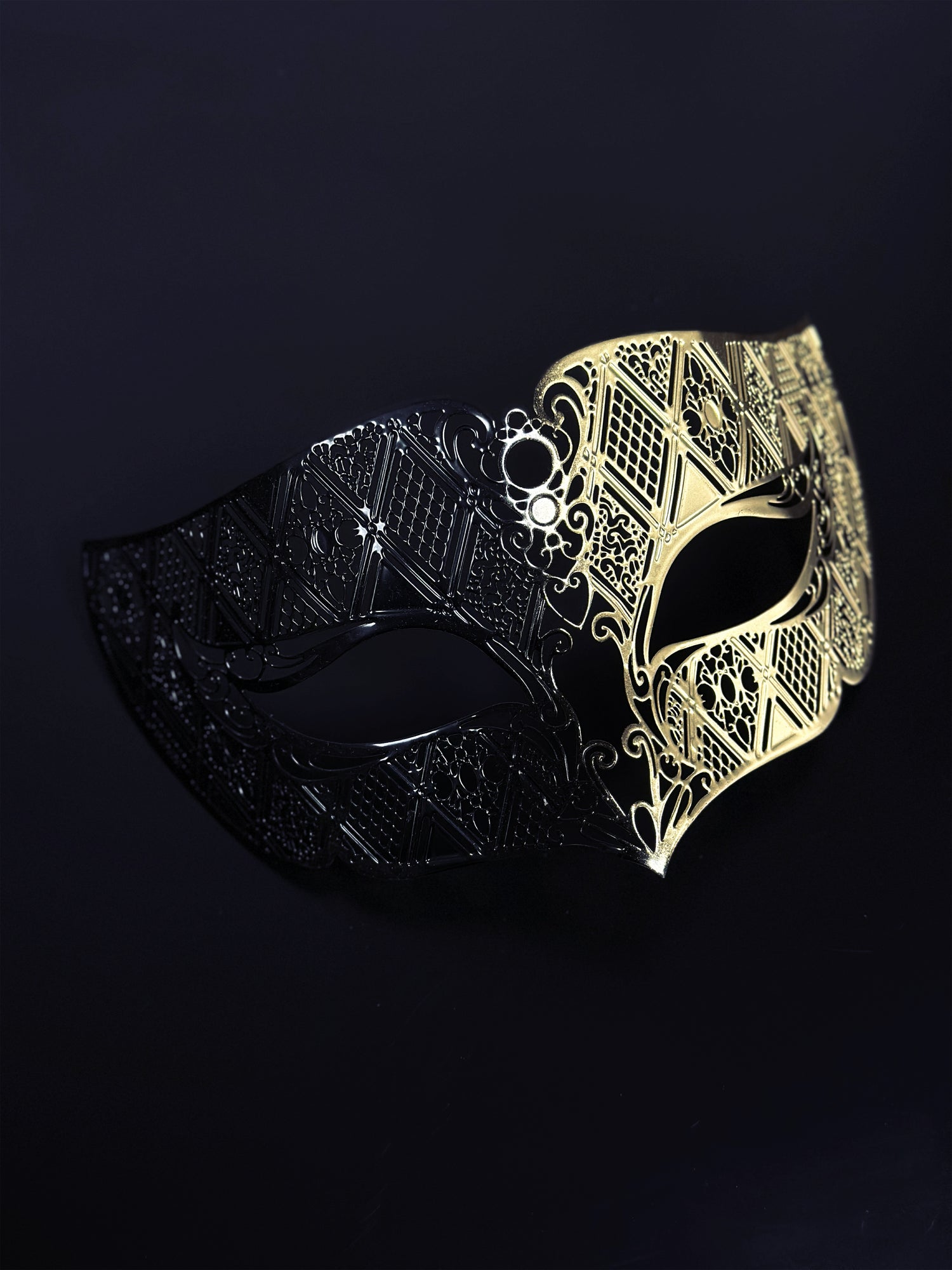 Men’s black and gold Venetian masquerade mask with geometric filigree design.