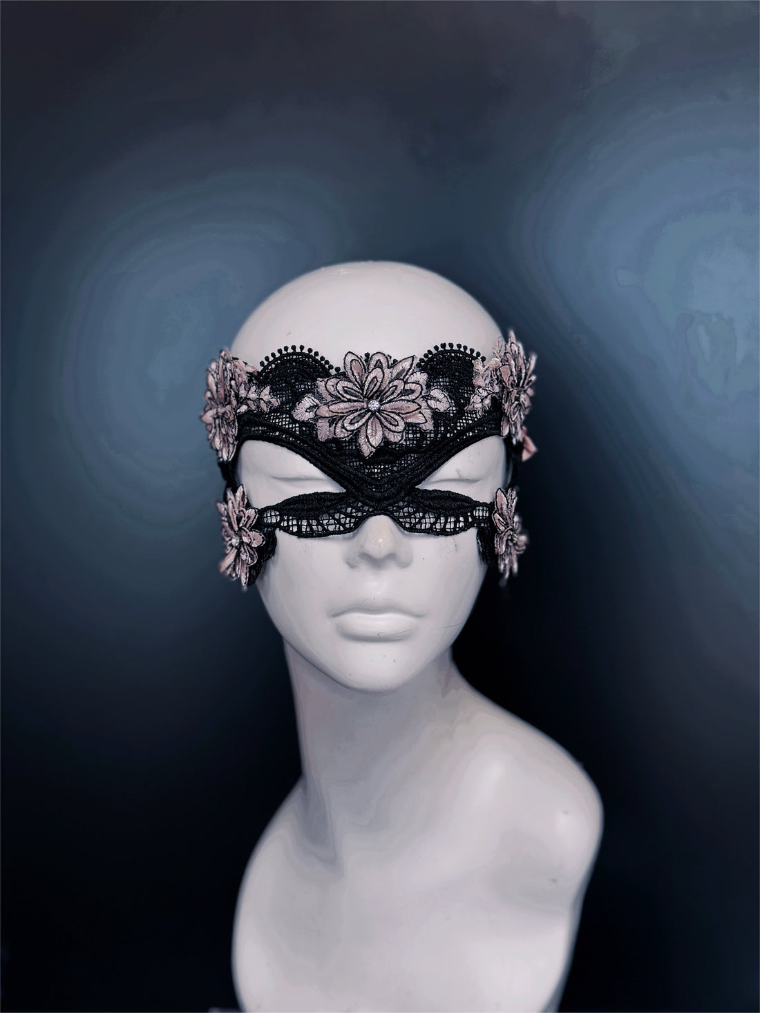 Black lace masquerade mask with pink floral embroidery for women at masquerade balls or gothic weddings.