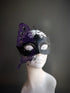 Black and purple half-face masquerade mask with butterfly wing embellishment