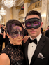Black and purple Venetian couples masquerade mask set featuring a men’s black eye mask with amethyst glitter accents and a women’s swan filigree rhinestone mask for masquerade balls, Mardi Gras, black tie parties, and formal costume events.