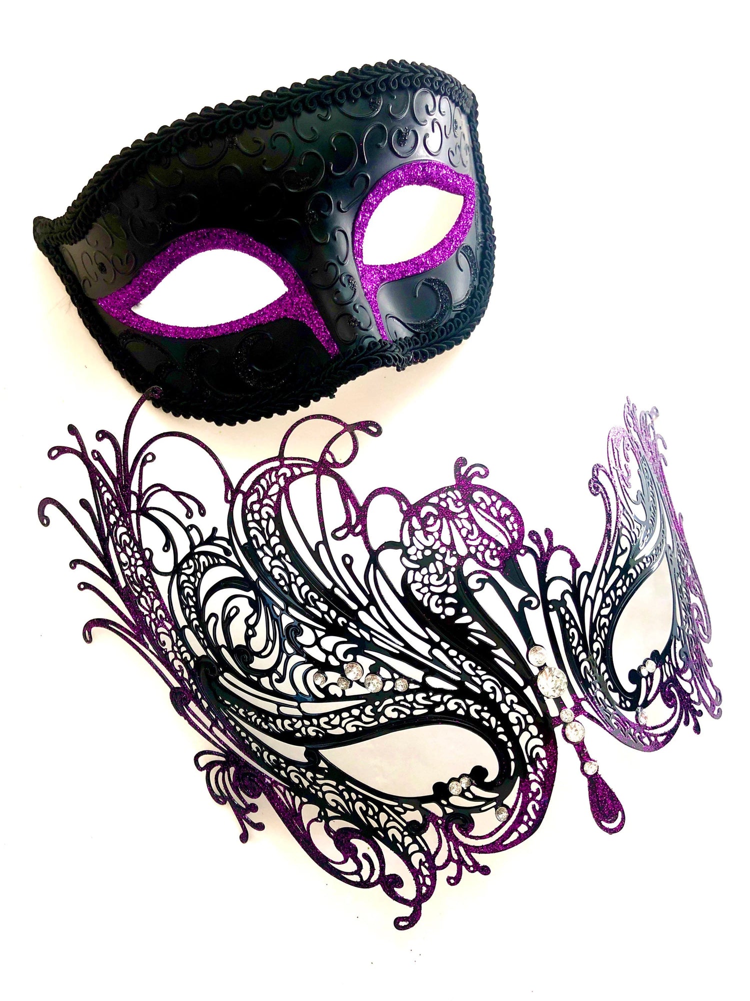 Black and purple Venetian couples masquerade mask set with men’s amethyst glitter eye mask and women’s swan filigree rhinestone mask for formal masquerade ball.