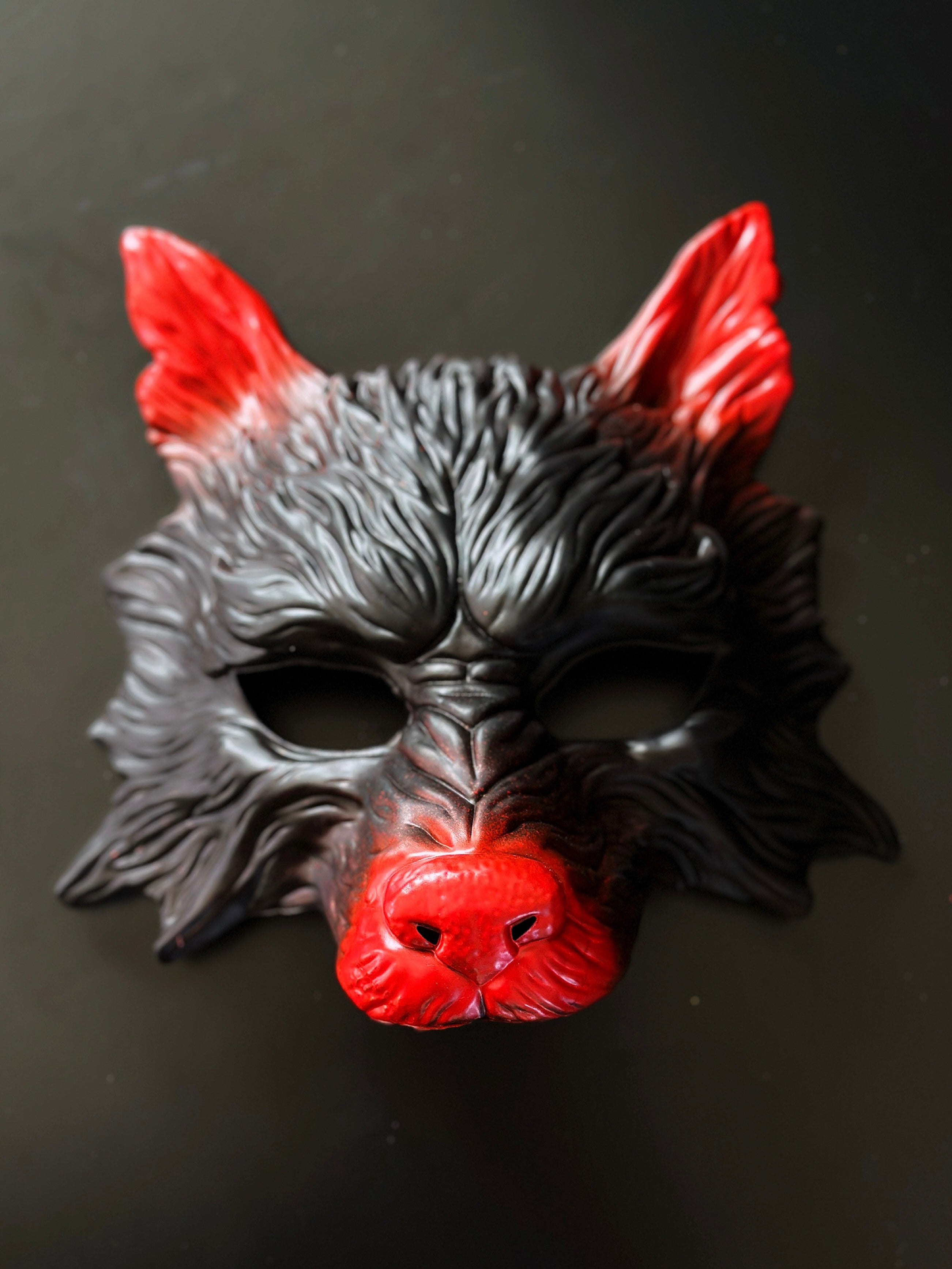 Black and red wolf masquerade mask with sculpted details for costume and cosplay events.