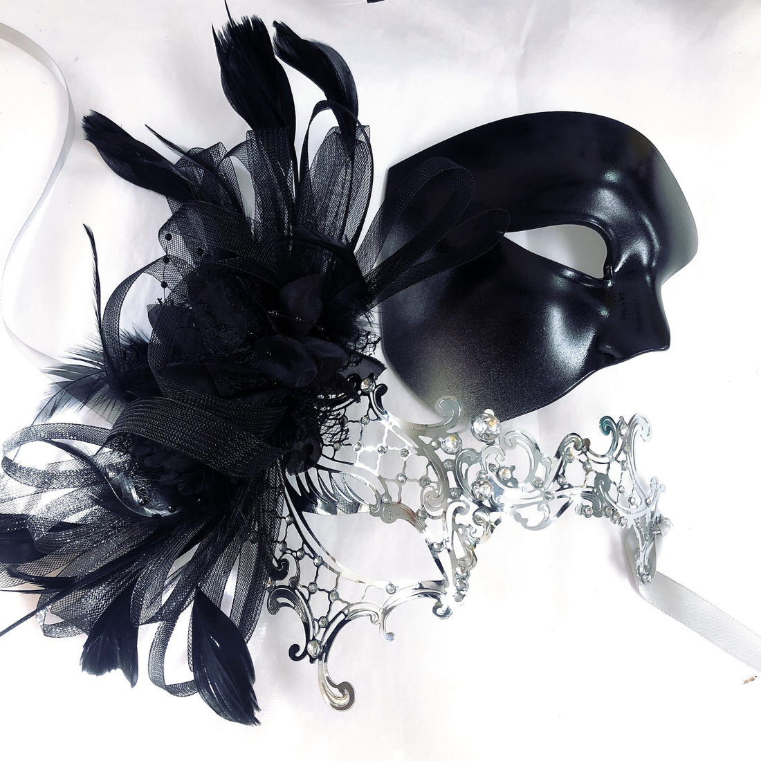 Black and silver couples masquerade masks with feathers, rhinestones, and elegant Venetian details.