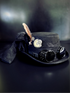 Gothic steampunk costume hat with black fabric, goggles, and vintage embellishments

