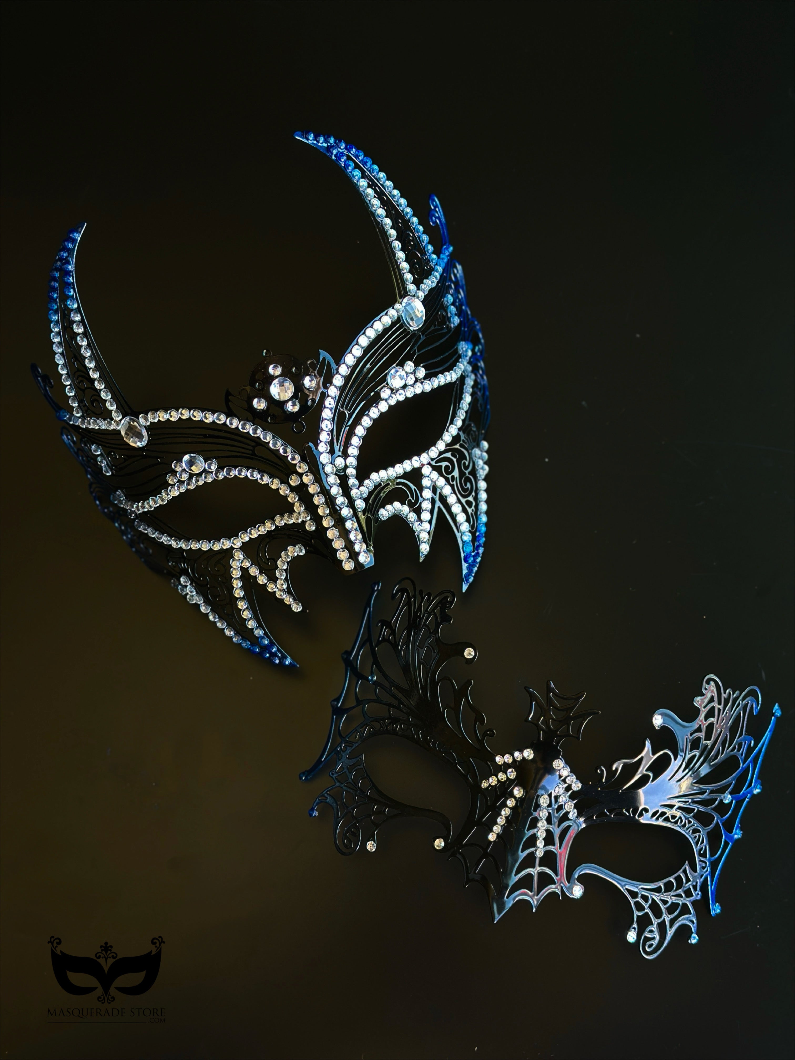Blue and black couples masquerade mask set with a horned rhinestone masquerade mask and a spiderweb-style eye mask for gothic formal events.