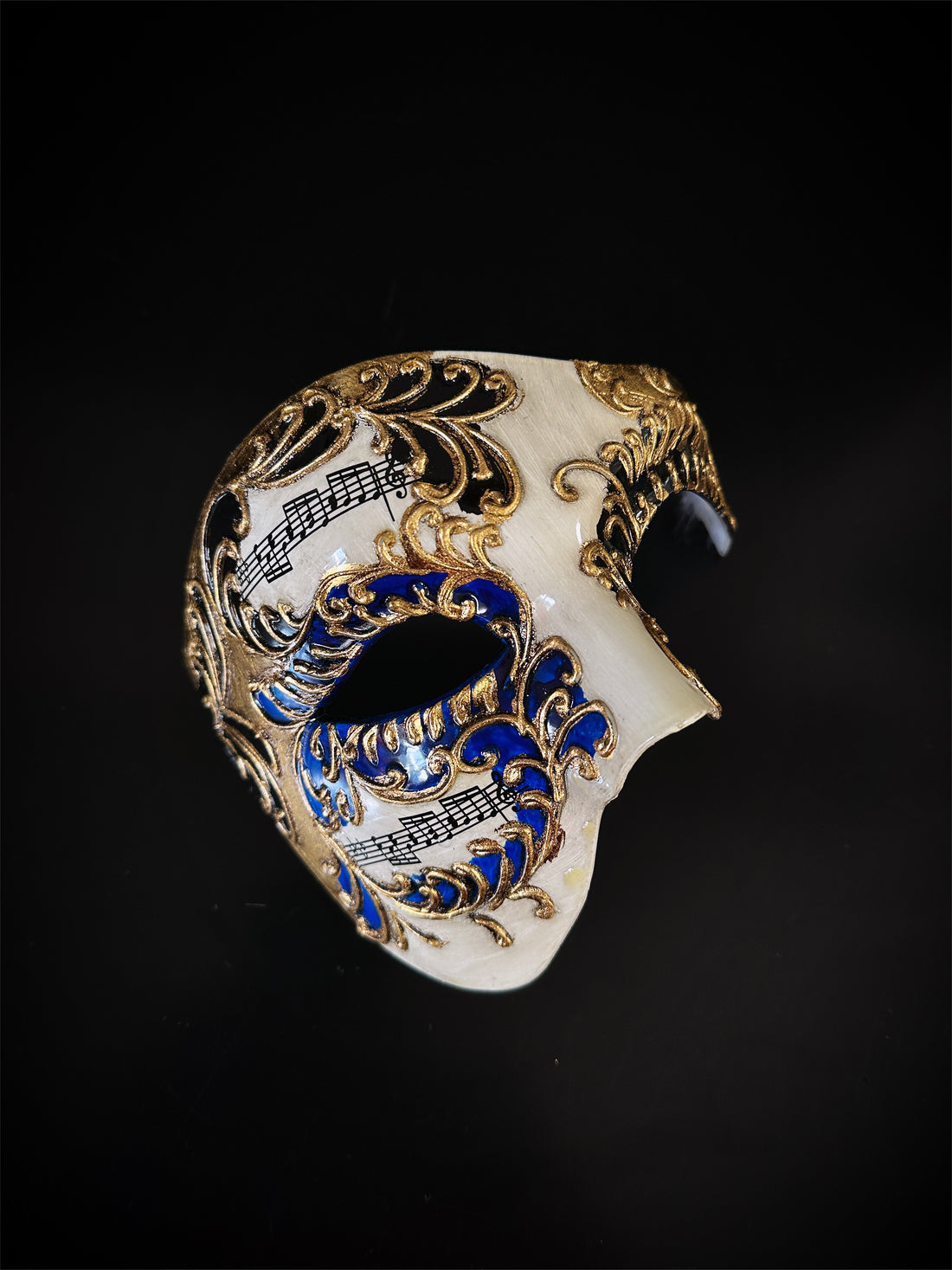 Half-face masquerade mask in blue and gold with ornate baroque scrolls