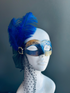 Blue and gold couples masquerade masks, men’s simple design, women’s mask with feather and dotted veil.