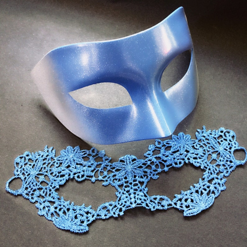 Blue metallic men’s masquerade mask with matching women’s blue lace masquerade mask for couples.
