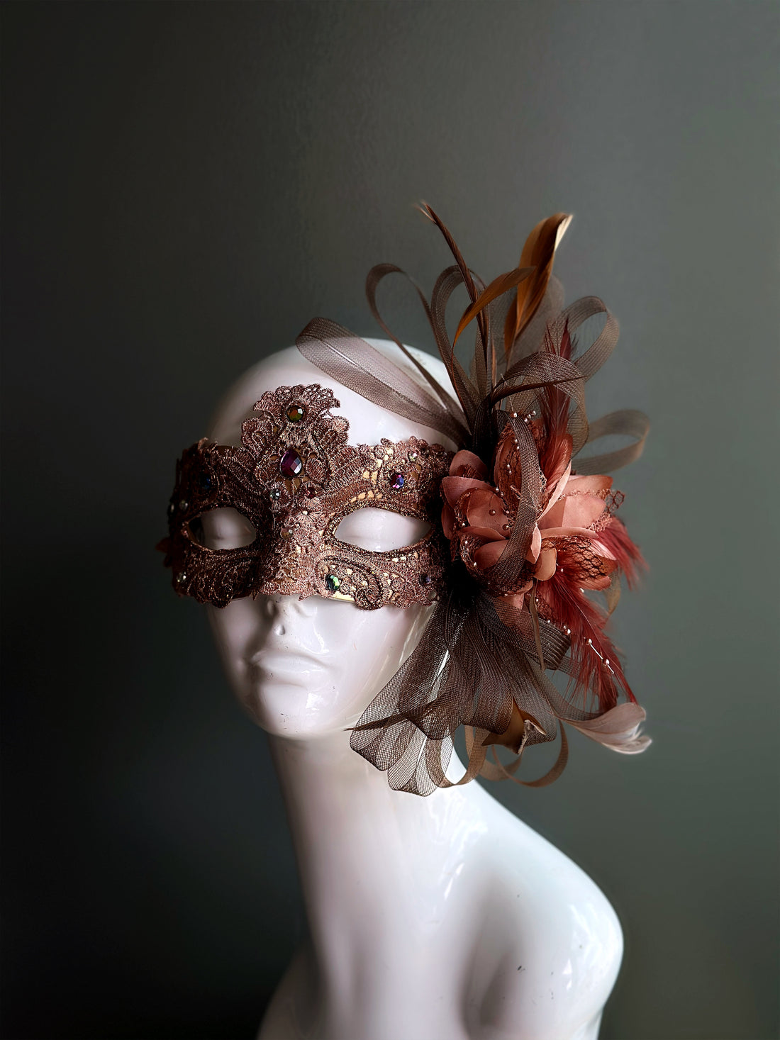 Bronze jeweled lace masquerade mask with rhinestones, floral accents, and feathers for masquerade ball, prom, or Halloween.