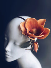 Autumn-inspired floral headpiece with burnt orange magnolia bloom and leaf detail for seasonal fashion events