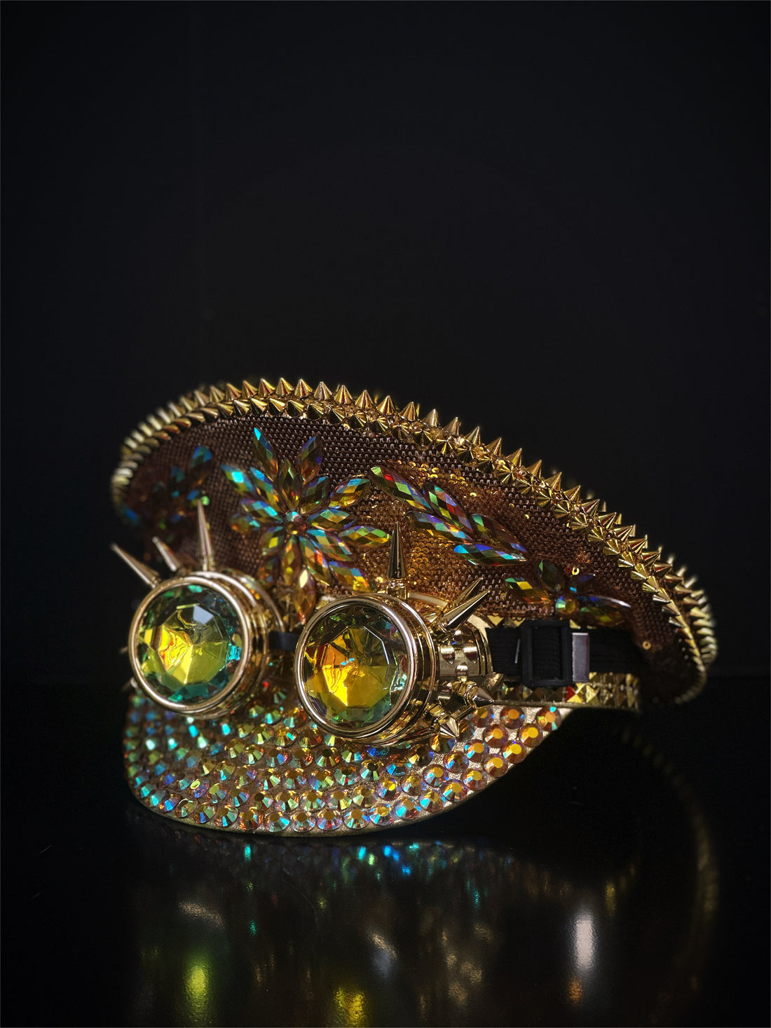Iridescent stone gold captain hat with spiked goggles.