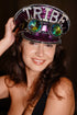 Purple sequin captain hat with the word "Tribe" in iridescent letters and spiked goggles.