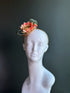 Coral floral straw fascinator headband with sage green loops.
