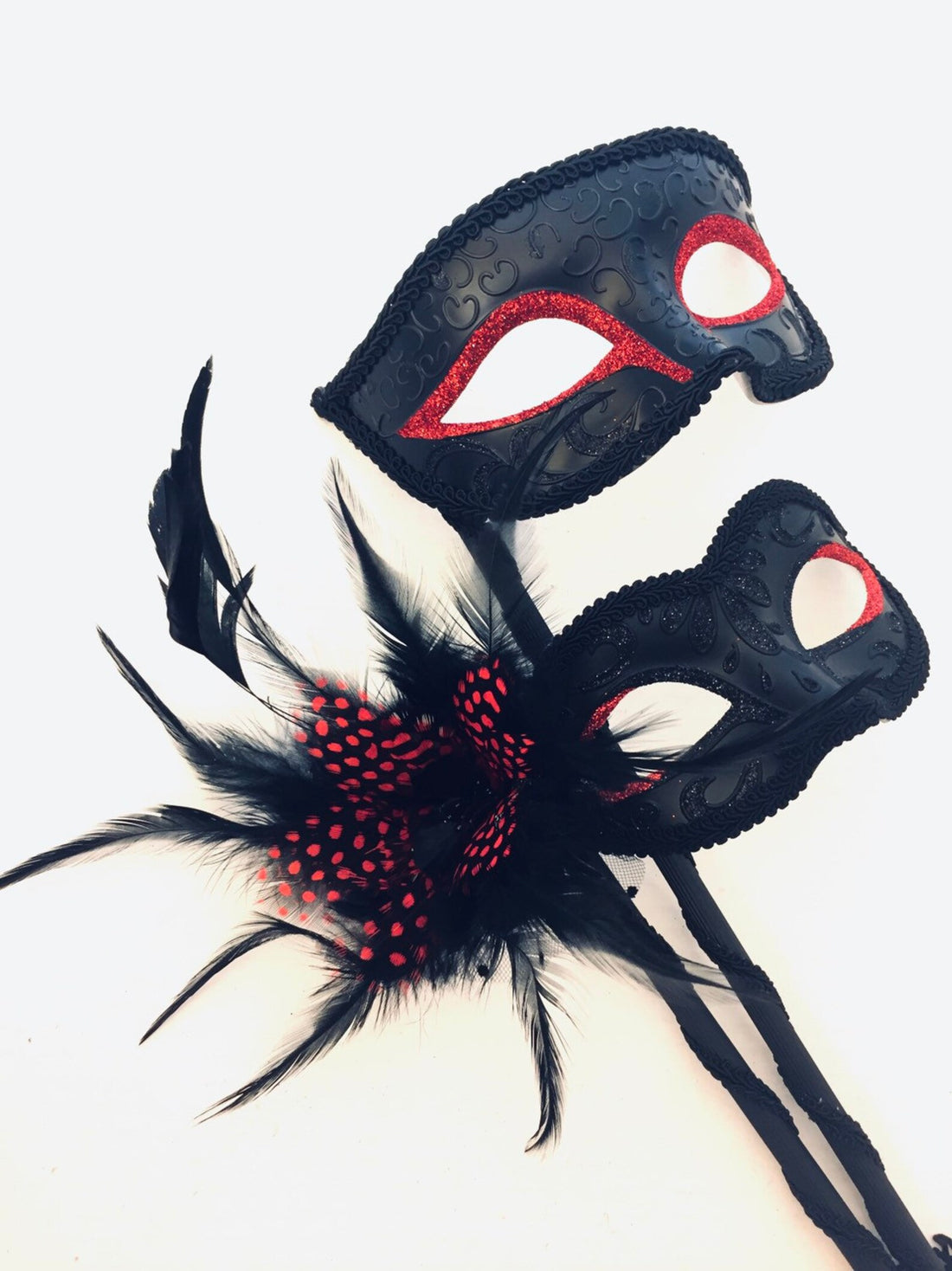 Black masks with red glitter eyes and black handheld tassel sticks.