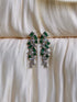 Emerald green geometric drop earrings with silver setting and cascading crystal accents.