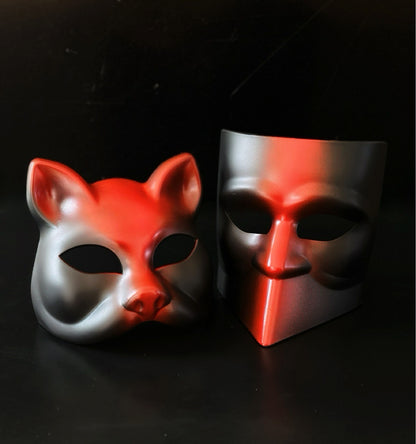 Red and black dual-style masquerade mask set with fox and modern face designs for theatrical events.