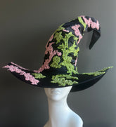 Black witch hat with pink and green beaded floral embroidery and wide brim design.