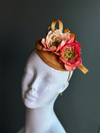 Floral straw fascinator headband with coral and blush flowers.