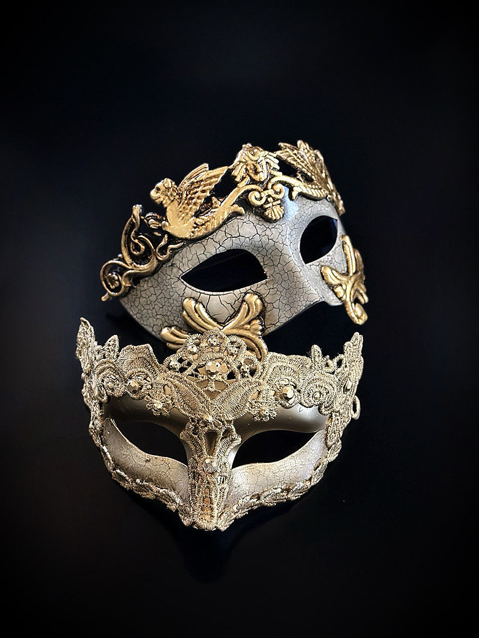 Elegant gold masquerade masks with ornate baroque detailing, one with birds and one with lace, perfect for gala nights.

