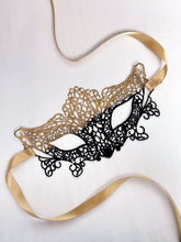 Delicate gold lace masquerade mask with black accents, ideal for formal parties
