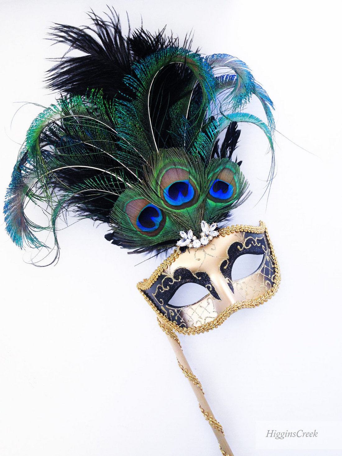 Venetian gold and black masquerade mask on stick with peacock feathers and rhinestones.