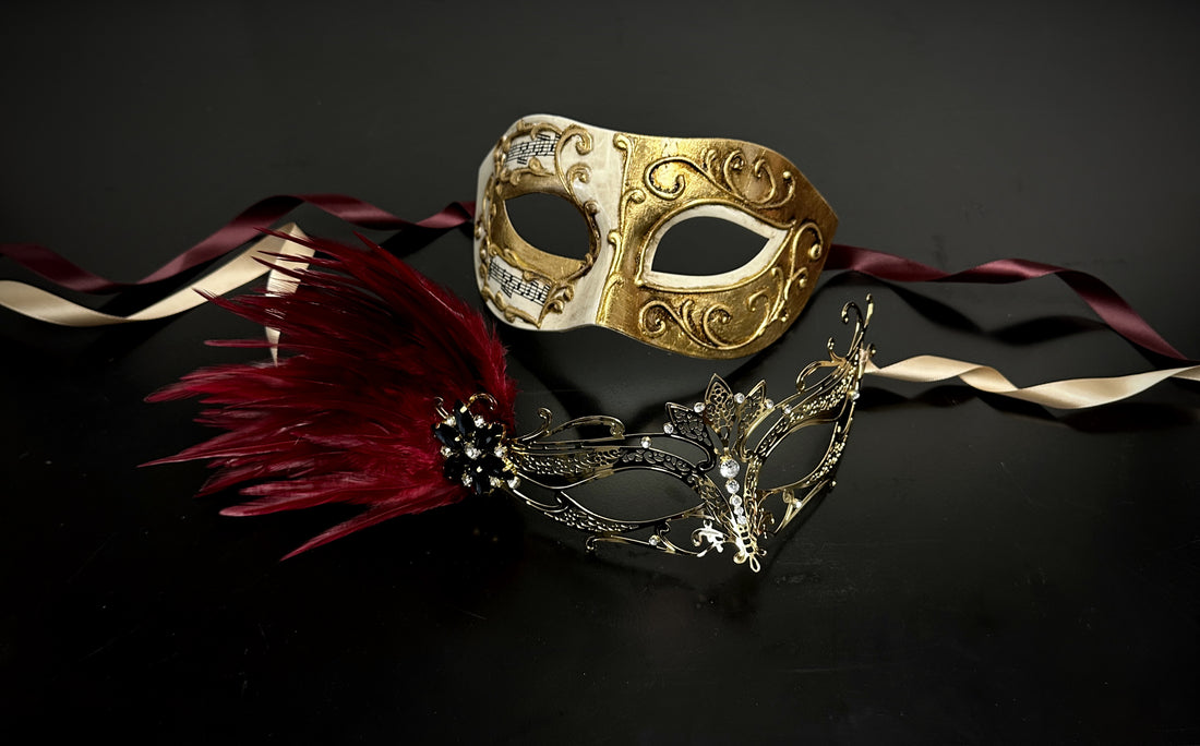 Elegant couples masquerade mask set featuring a gold Venetian music note mask and a gold filigree mask with red feathers and gemstones.