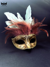 Gold masquerade mask with glitter details and red and white feather plumes for Mardi Gras and balls