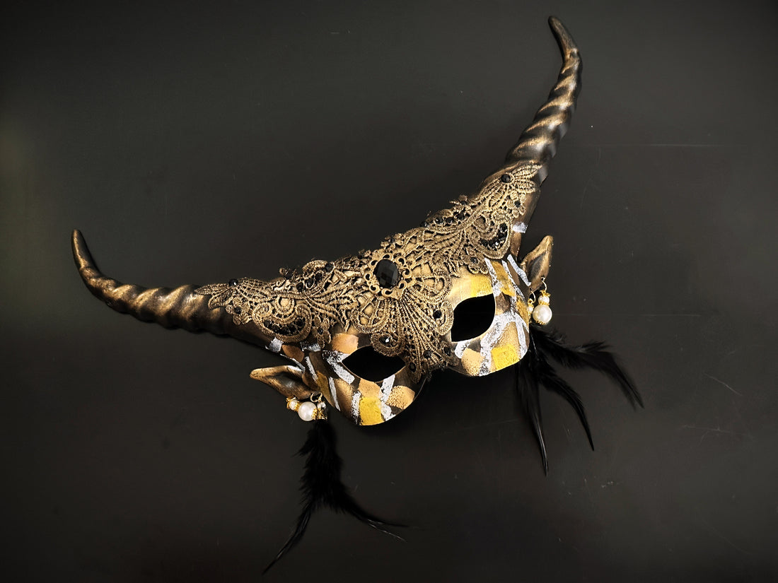 Black and gold horn masquerade mask with gothic lace, pearl earrings, and feathers – fantasy costume accessory.