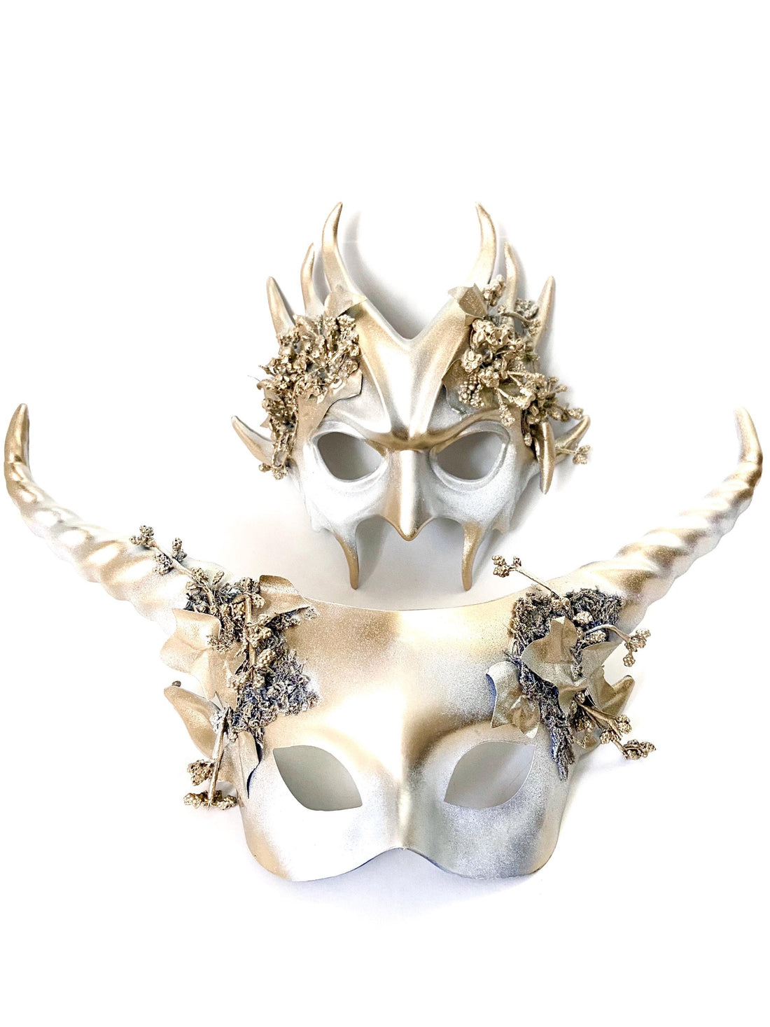 Elegant gold masquerade masks with horns and detailed floral embellishments for couples or themed galas.