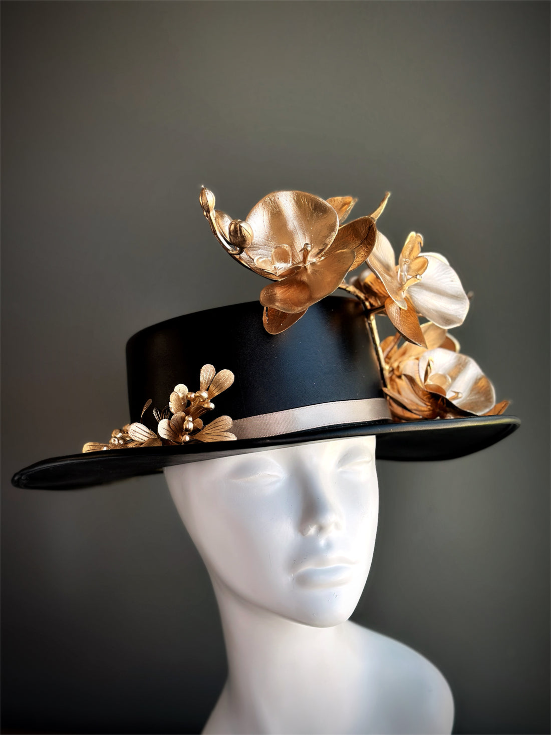 Statement black and gold floral event hat with sculpted orchid accents