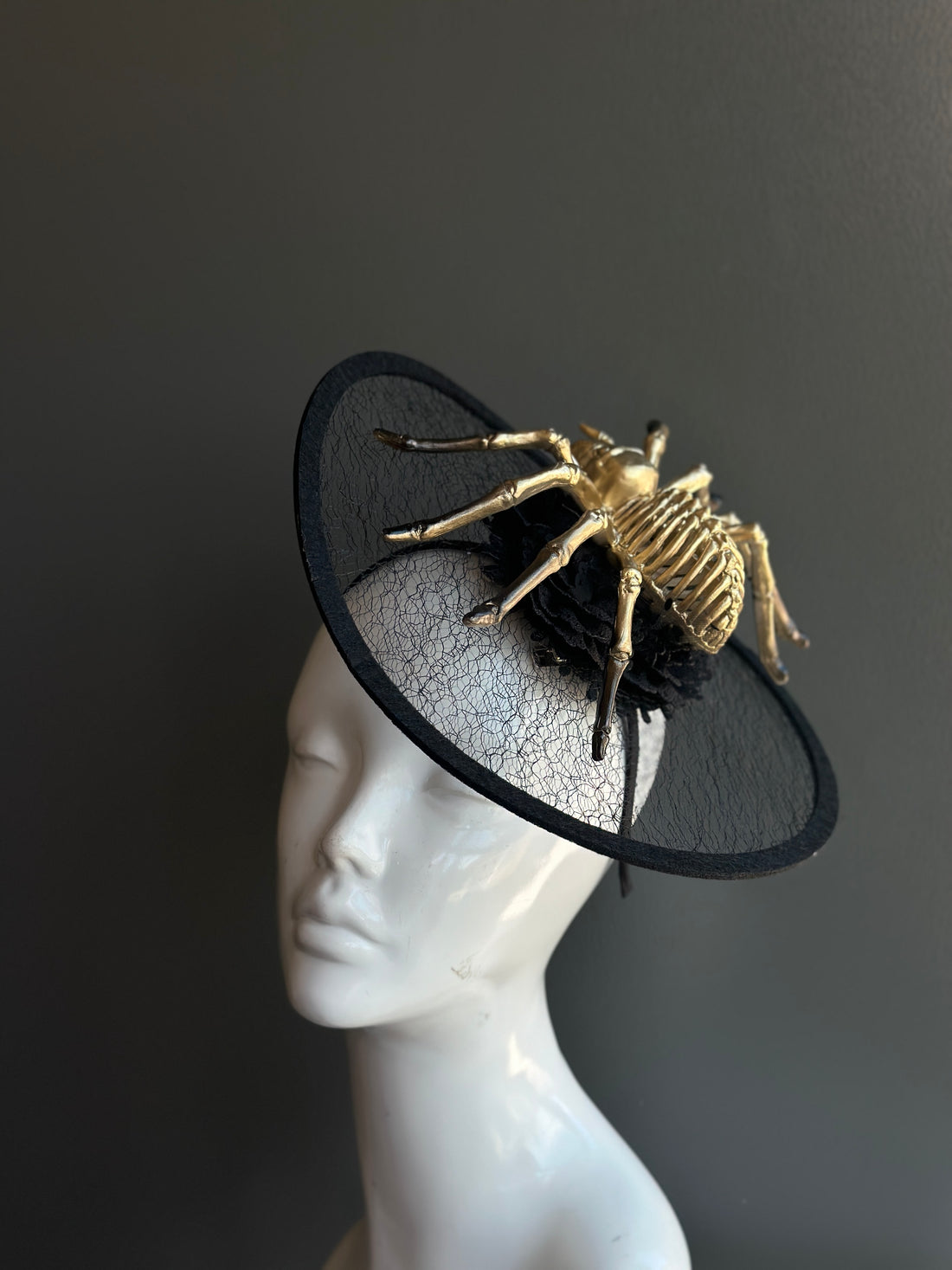 Gold skeleton spider Halloween fascinator hat with black mesh disc for witch or horror costumes