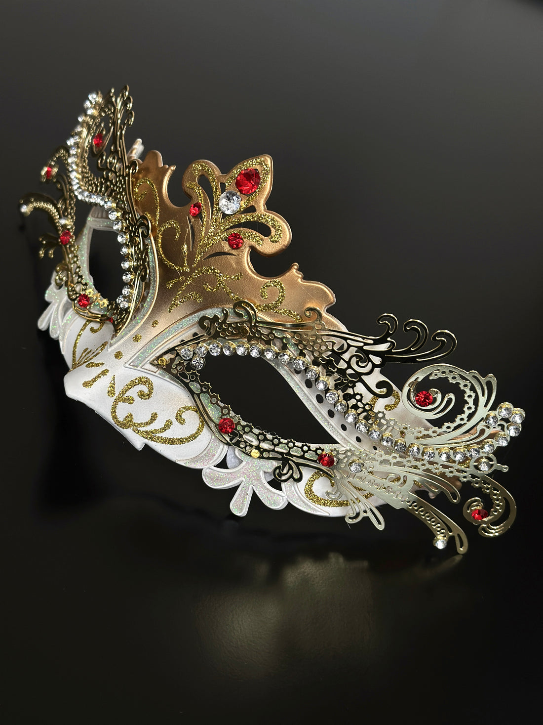 Gold and white women’s masquerade mask with rhinestones, glitter accents, and red gemstone details, ideal for Venetian masquerade balls and festive parties.