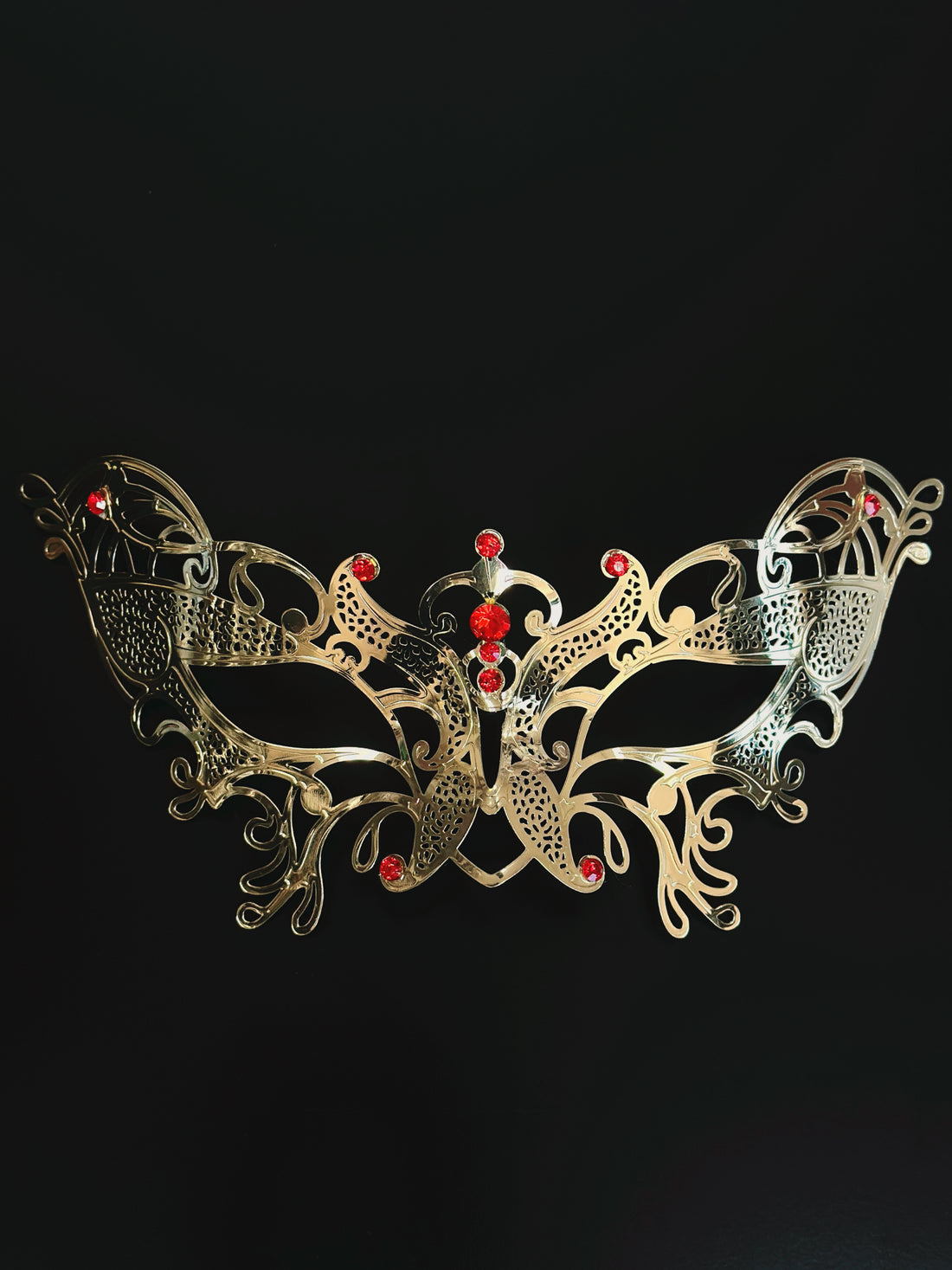 Gold women’s masquerade mask with filigree metal design and red rhinestones, perfect for Venetian masquerade balls, Mardi Gras, and prom.
