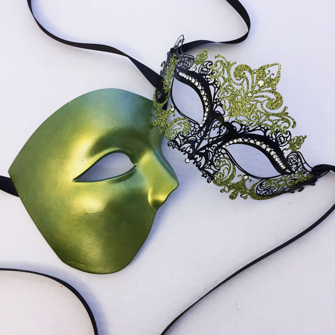 Green and black couples masquerade masks with glitter, rhinestones, and filigree design.