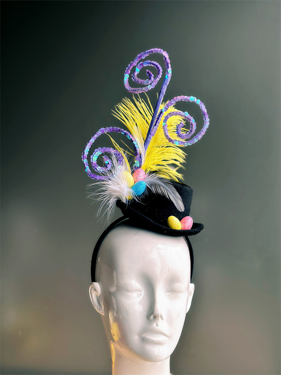 Black hat with purple swirls, feathers, and colorful Easter eggs.