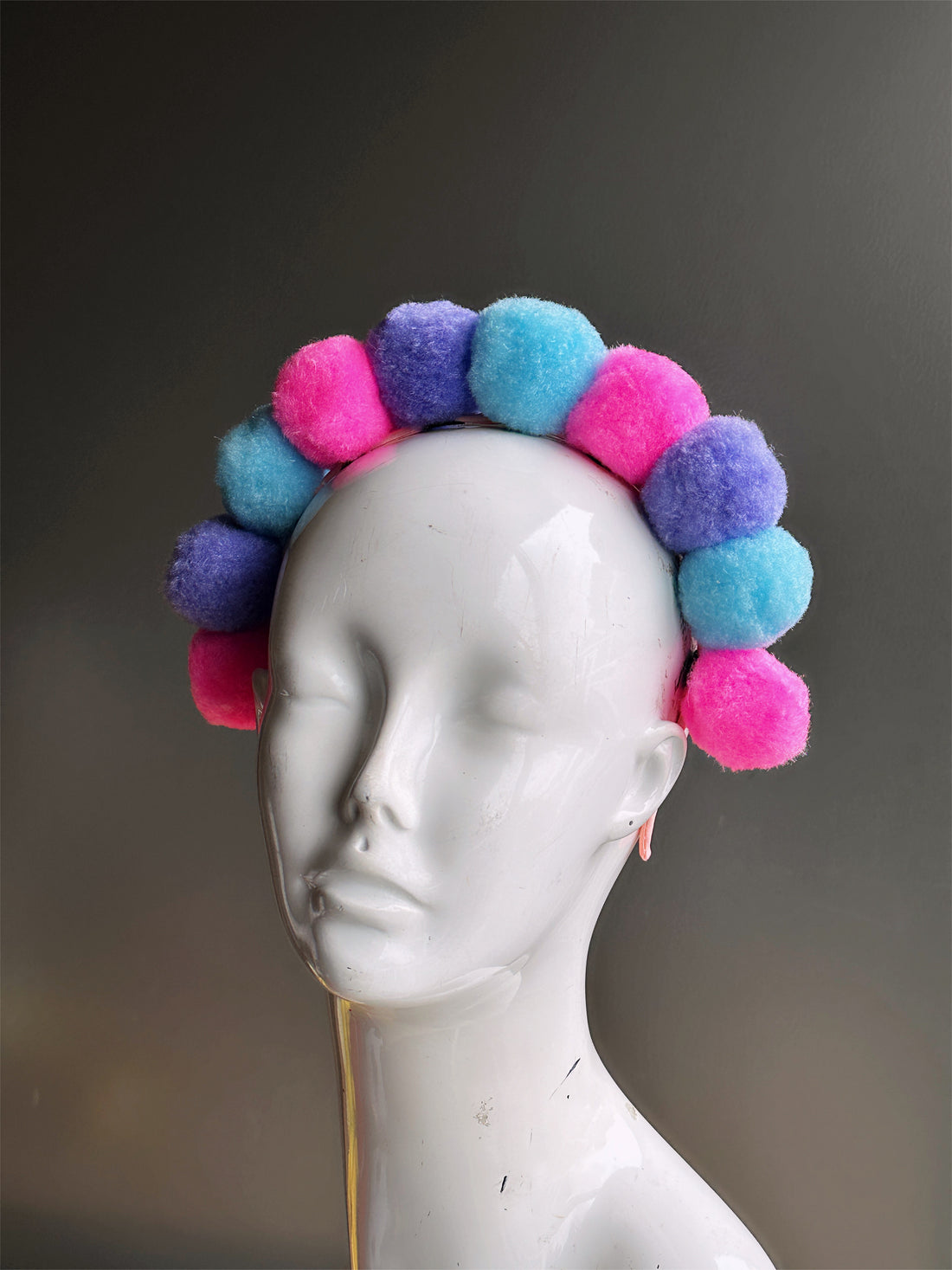 Headband with purple, blue, and pink pompoms.