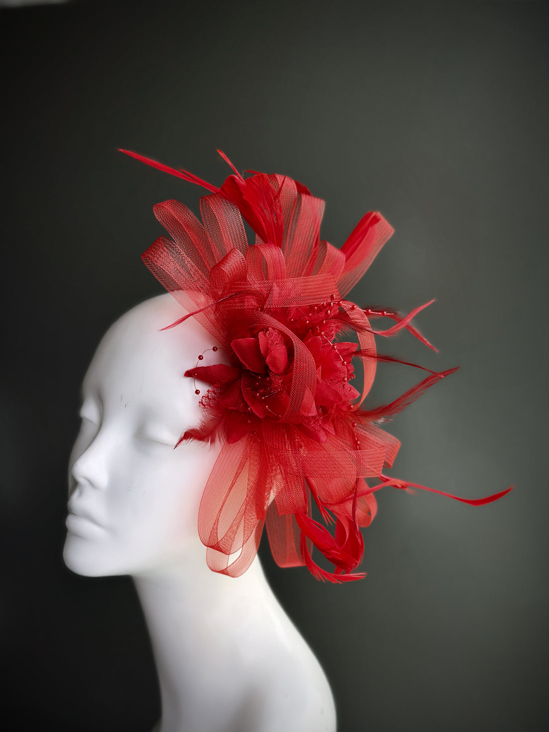 red fascinator hat with feather and tulle floral detailing