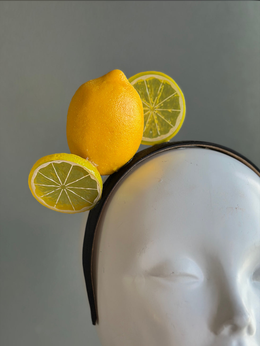 Yellow lemon fascinator headband with citrus slice detail for derby and summer themed events.