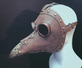 Copper-toned masquerade mask styled like a plague doctor with long beak and faux leather finish.