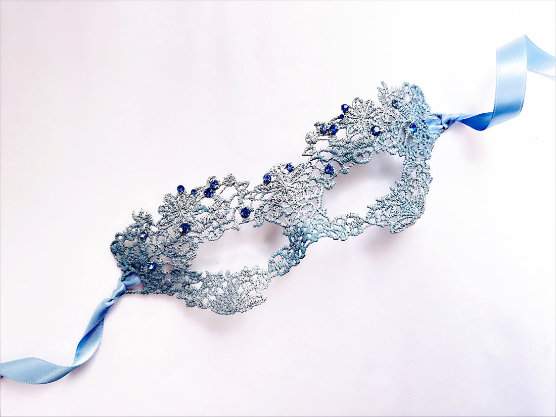 Light blue lace masquerade mask with rhinestone accents and satin ribbon ties for weddings, proms, and masquerade balls.