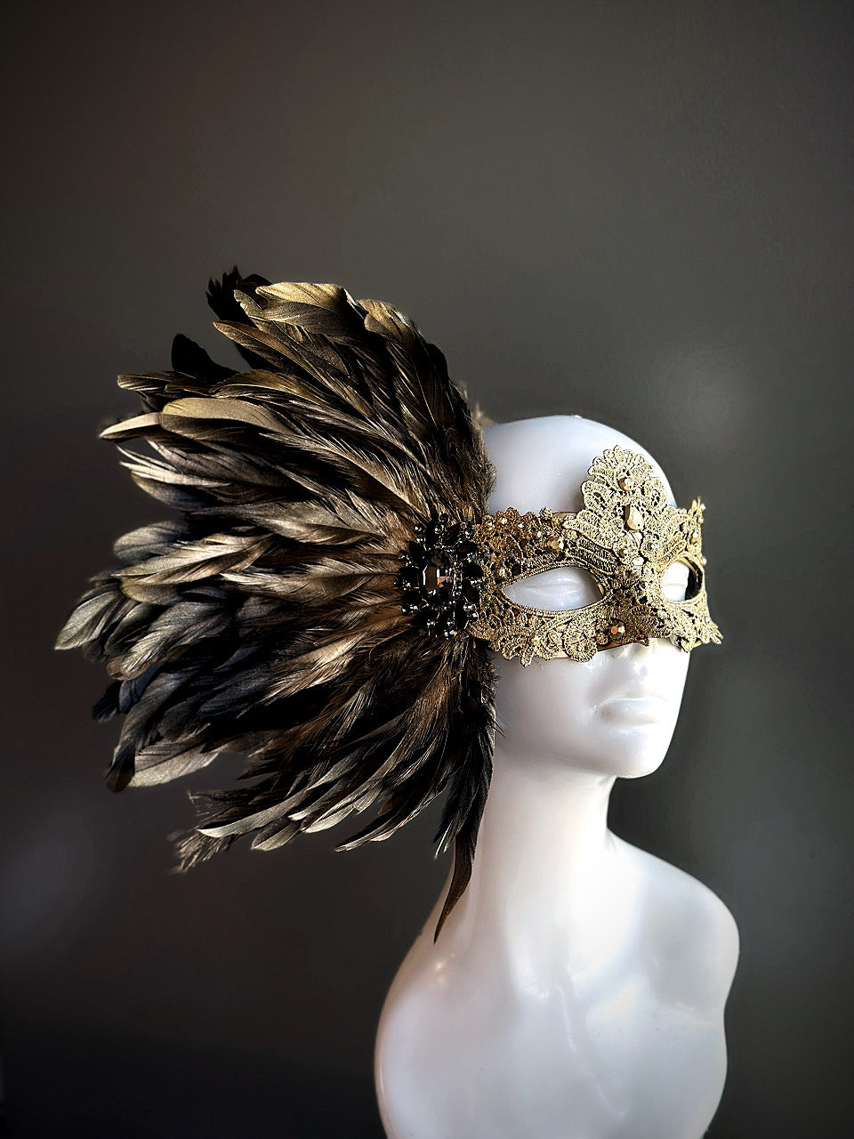 Elegant feather masquerade mask in gold with baroque-inspired lux detailing
