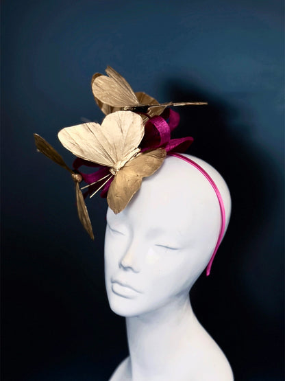Magenta fascinator hat with metallic gold butterfly headpiece for weddings and Derby.