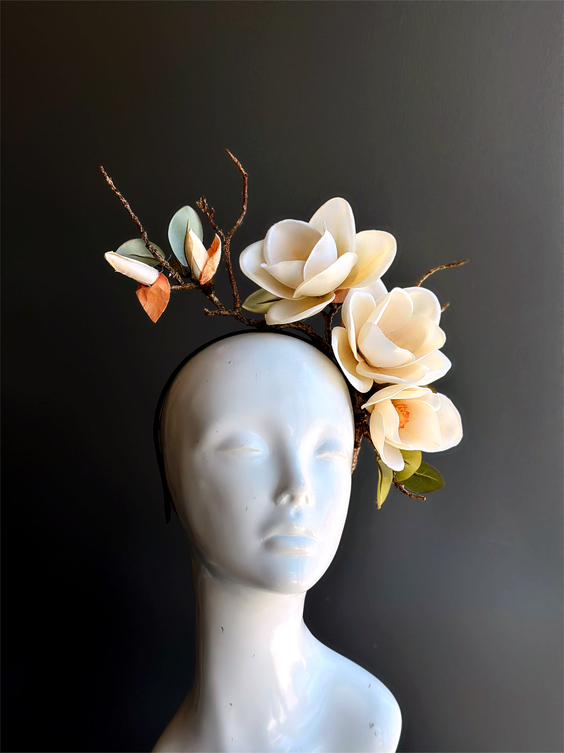 Bouquet headpiece featuring cream magnolia blossoms with branch accents on a headband for woodland weddings and festivals.